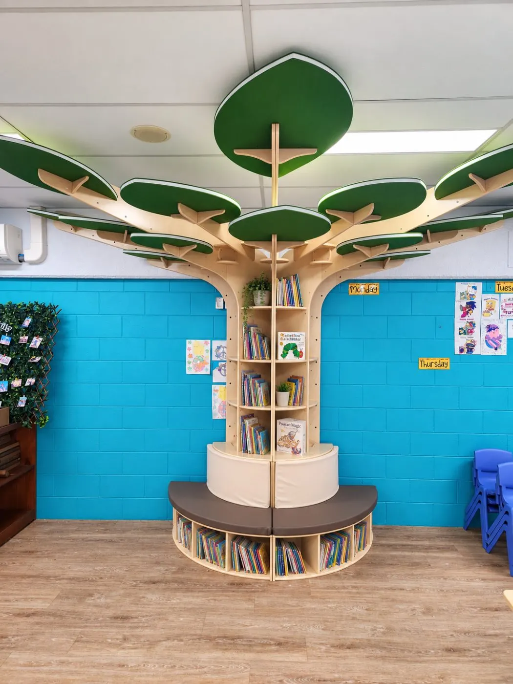 The junior kindy room book tree, a timber reading nook with leafy canopy and cushioned seat